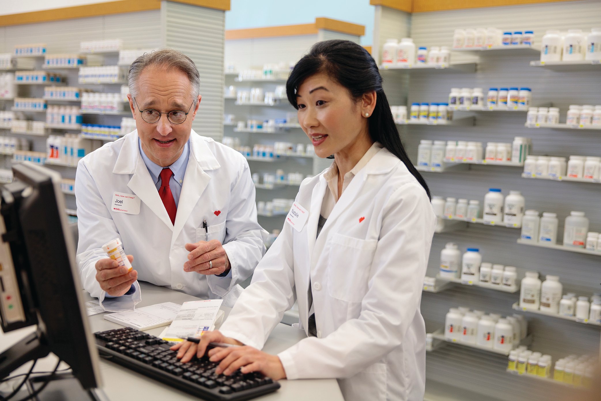 Two pharmacists collaborating while using a computer. 