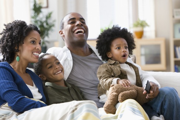 Young family watching television together.