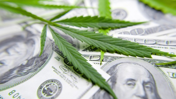 marijuana leaf over $100 bills.