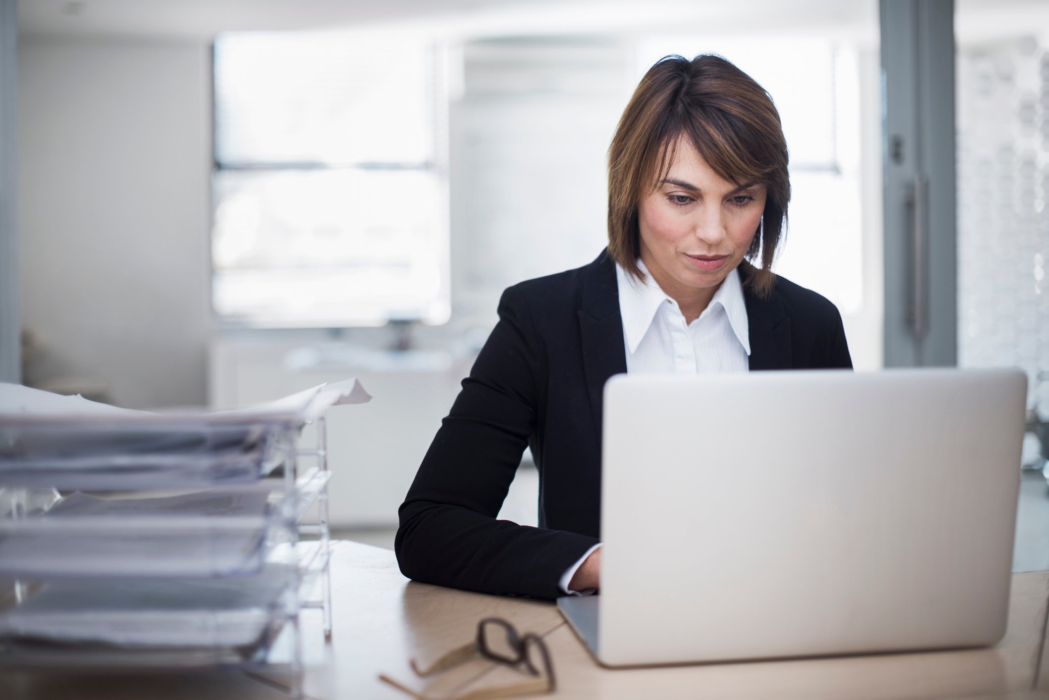 Business person typing on laptop.
