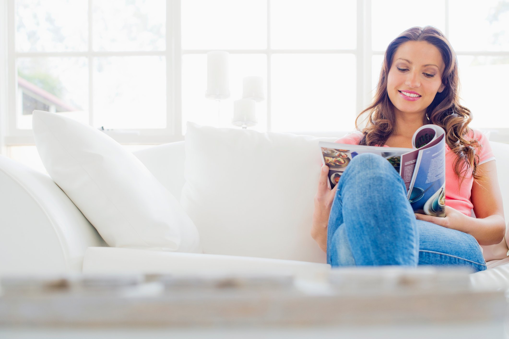 Person on couch reading a magazine.
