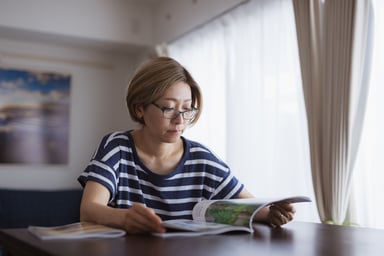 Person at a table reading a magazine