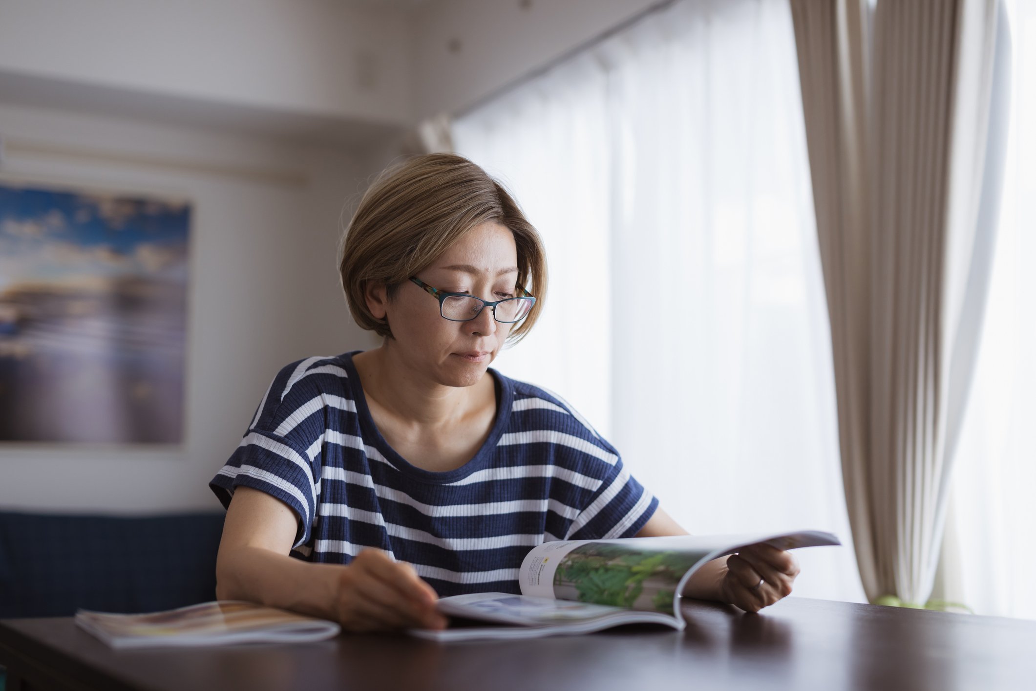 Person at a table reading a magazine
