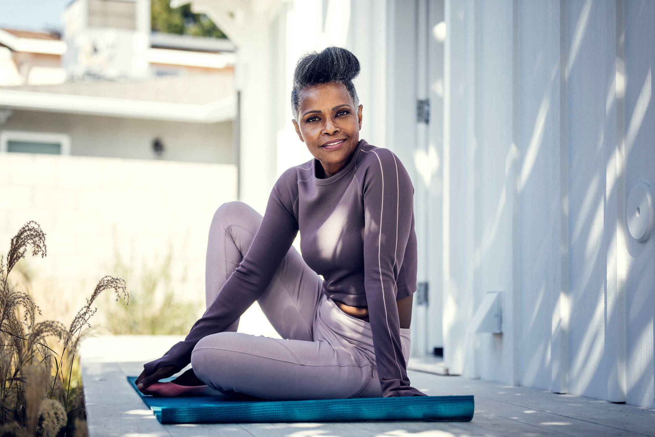 Person sitting on a yoga mat.