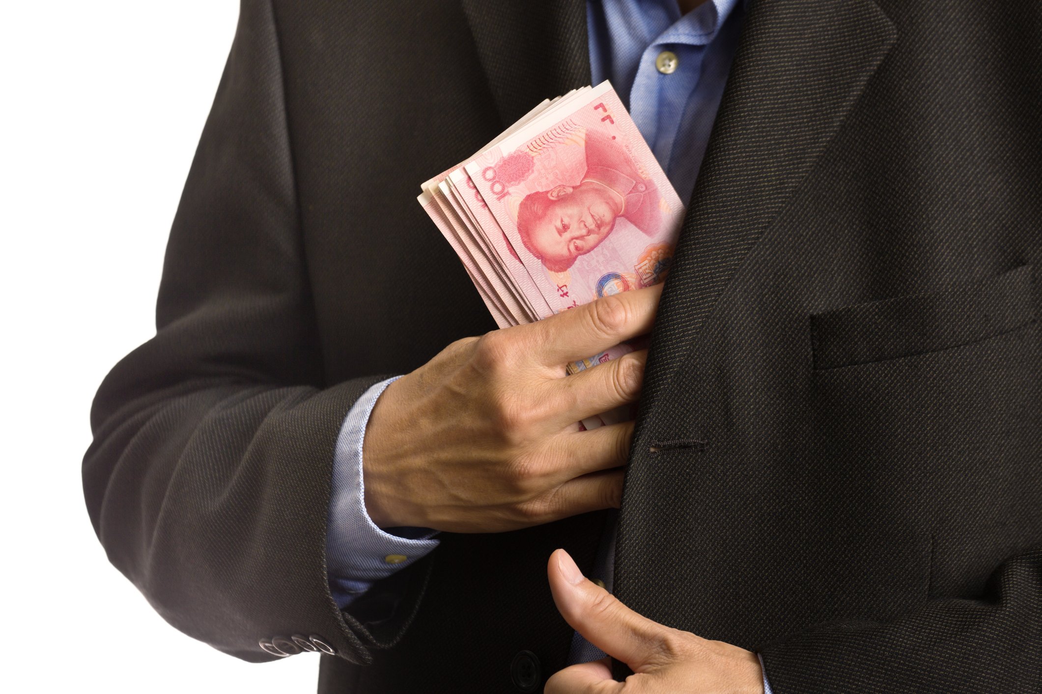 Closeup on businessman putting wad of yuan cash into suit pocket. 