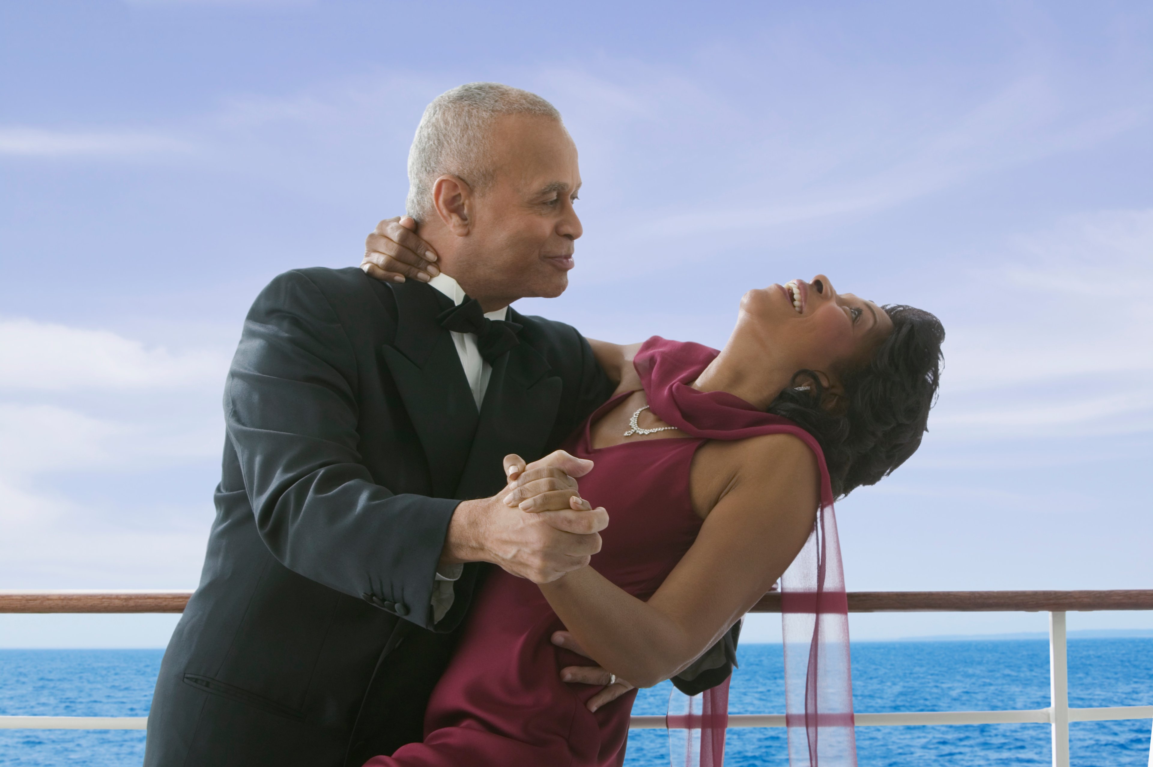 Two people dancing on a ship at sea.