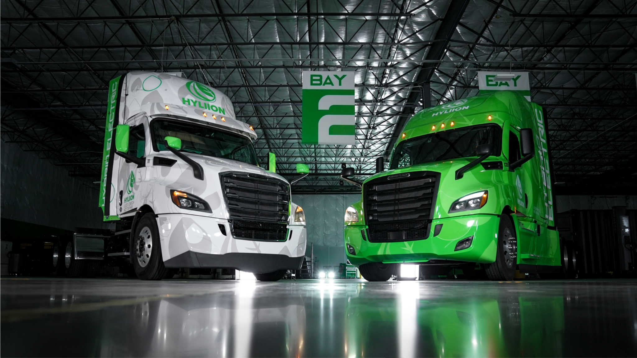One green and one white Hyliion semitruck.