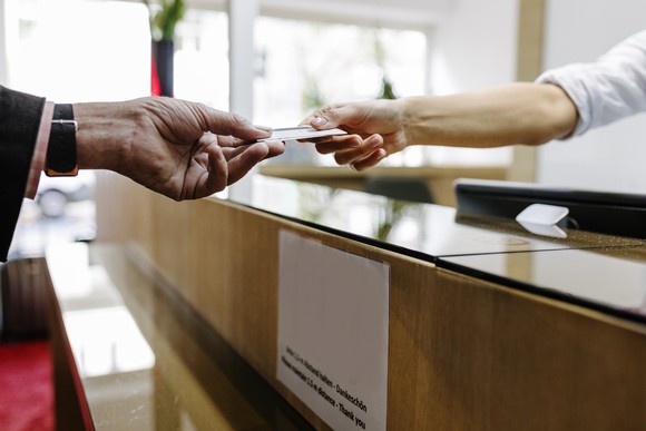 One person handing a credit card to another