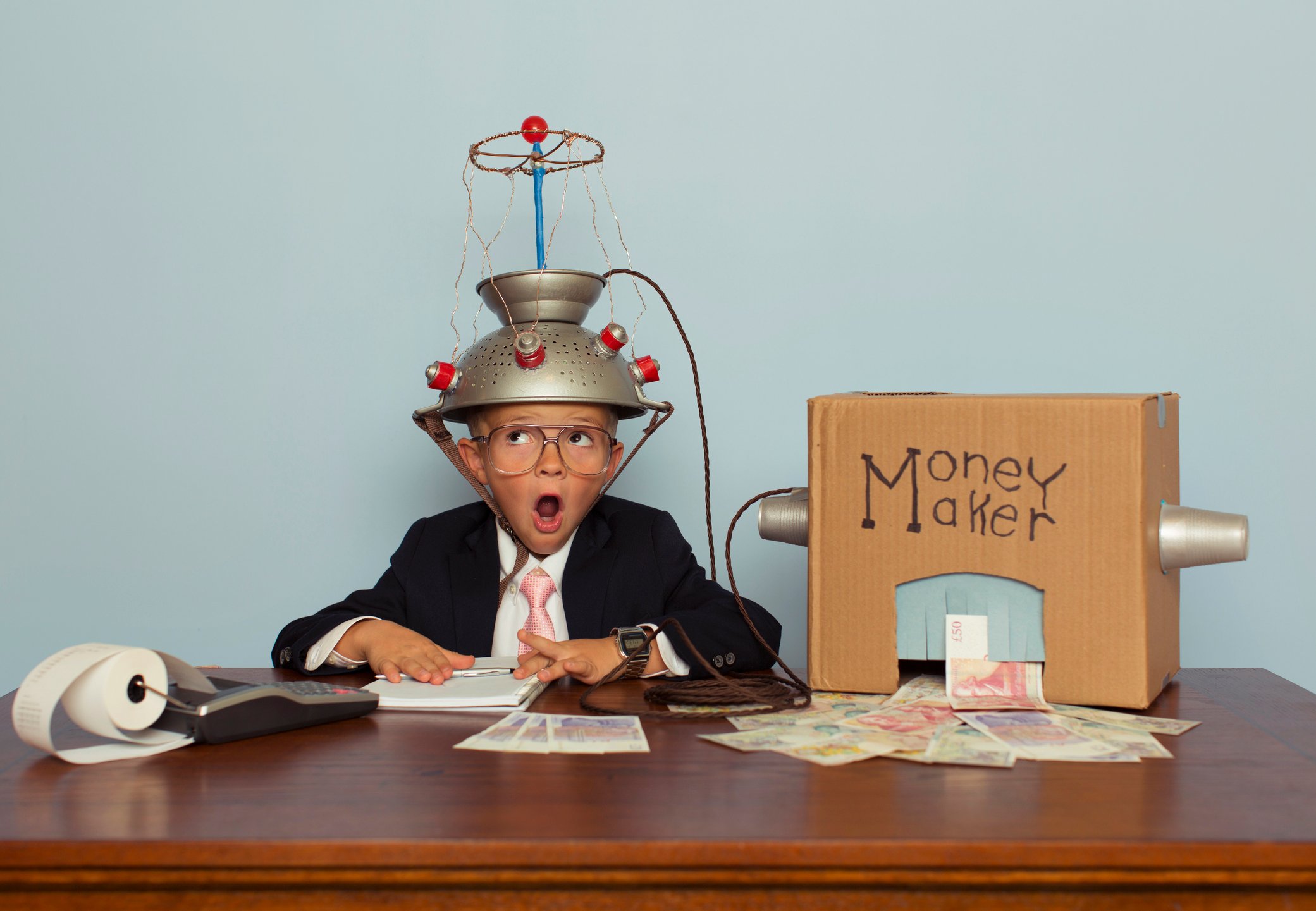 A child hooks up to a homemade "money maker" machine.