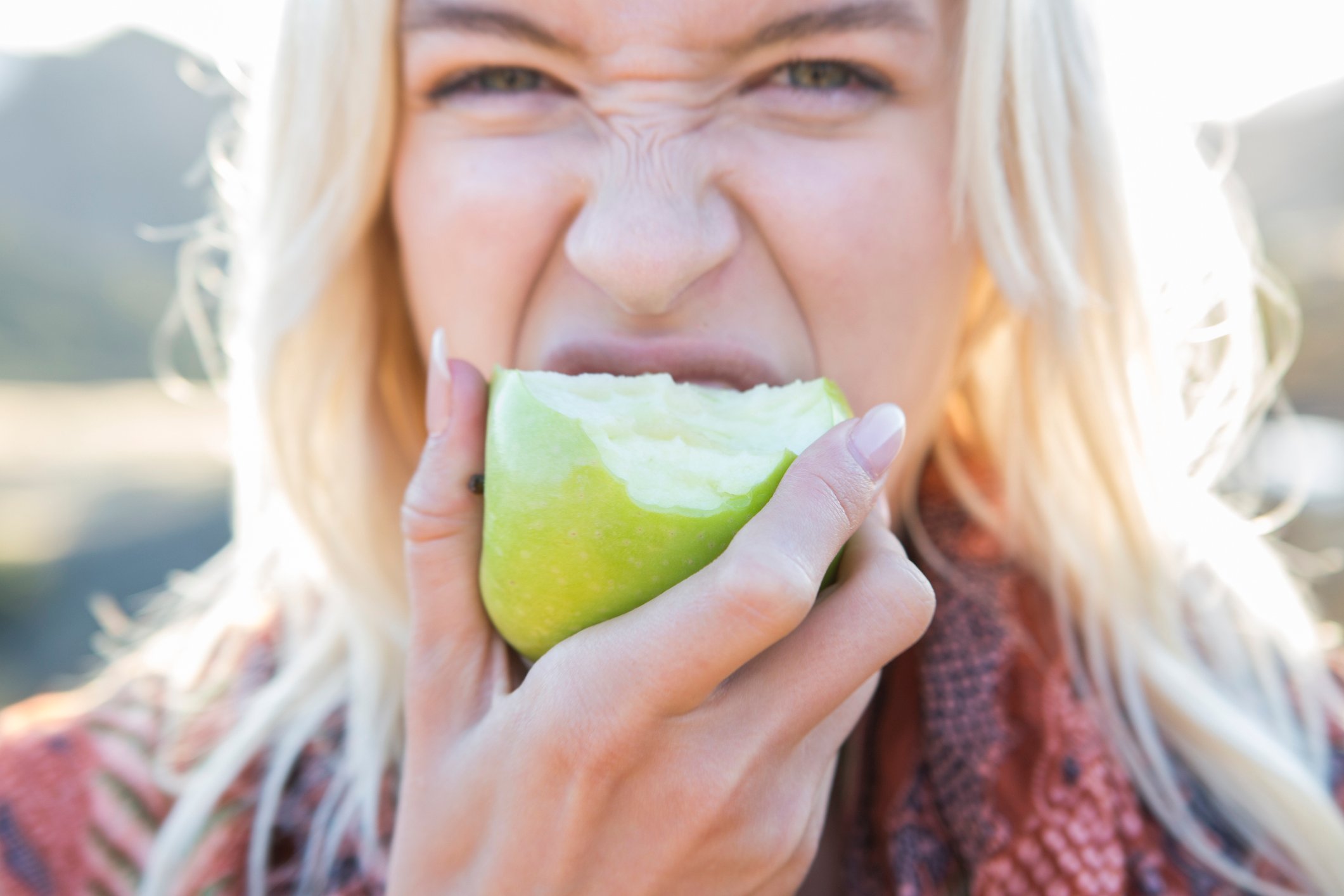 Person biting into an apple.