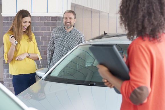 A father and daughter shopping for a used car together.