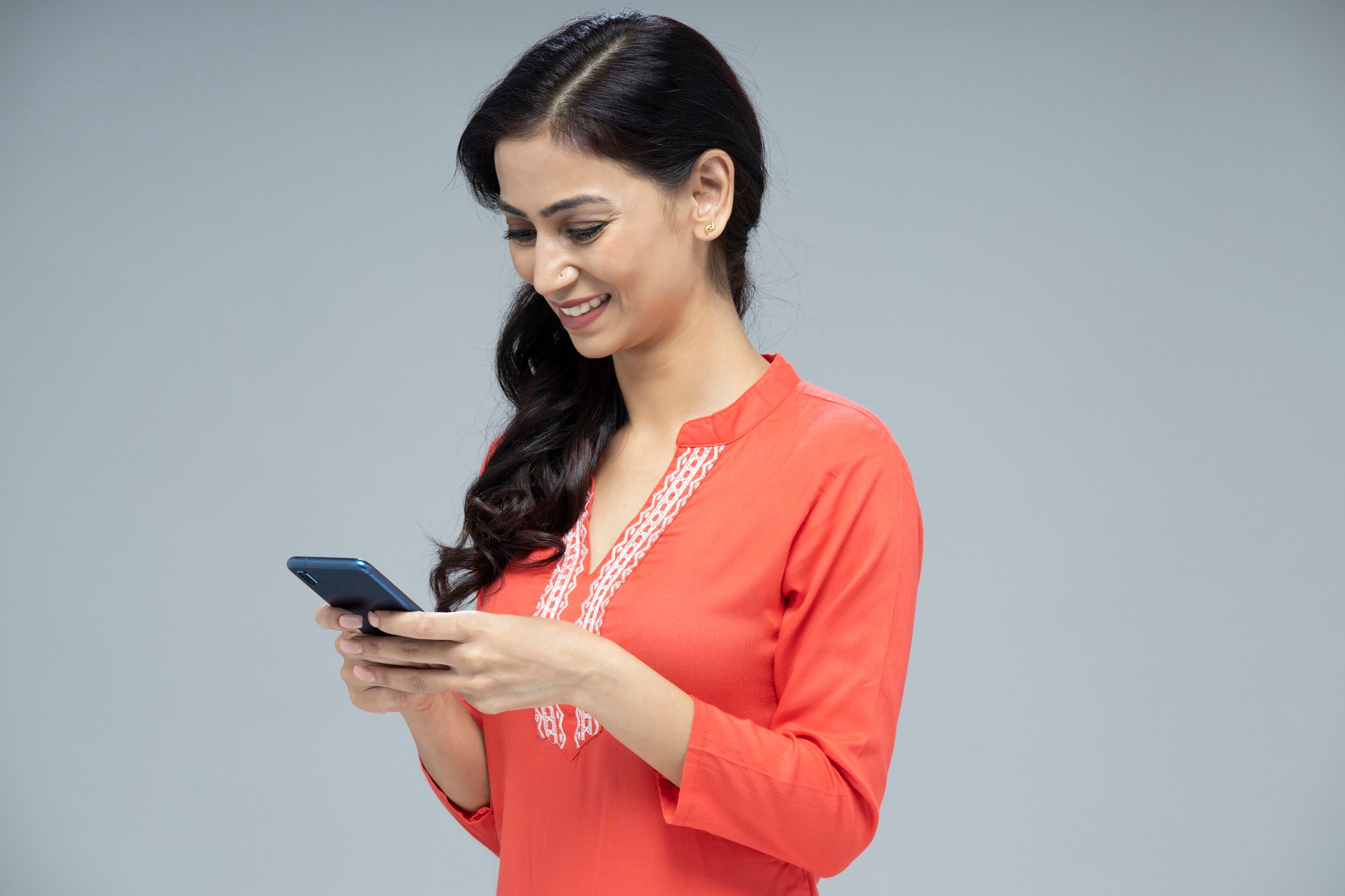 A smiling person holding a smartphone.