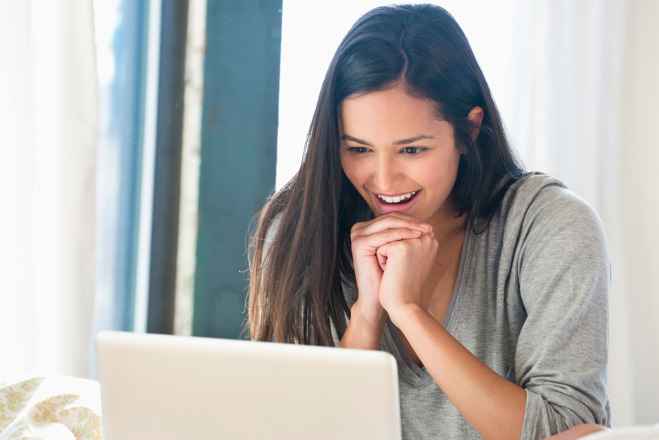 Young smiling woman looking at laptop
