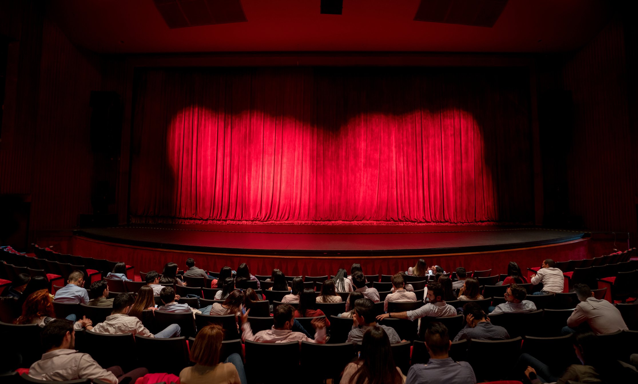 A crowded theater waits for a movie to start.