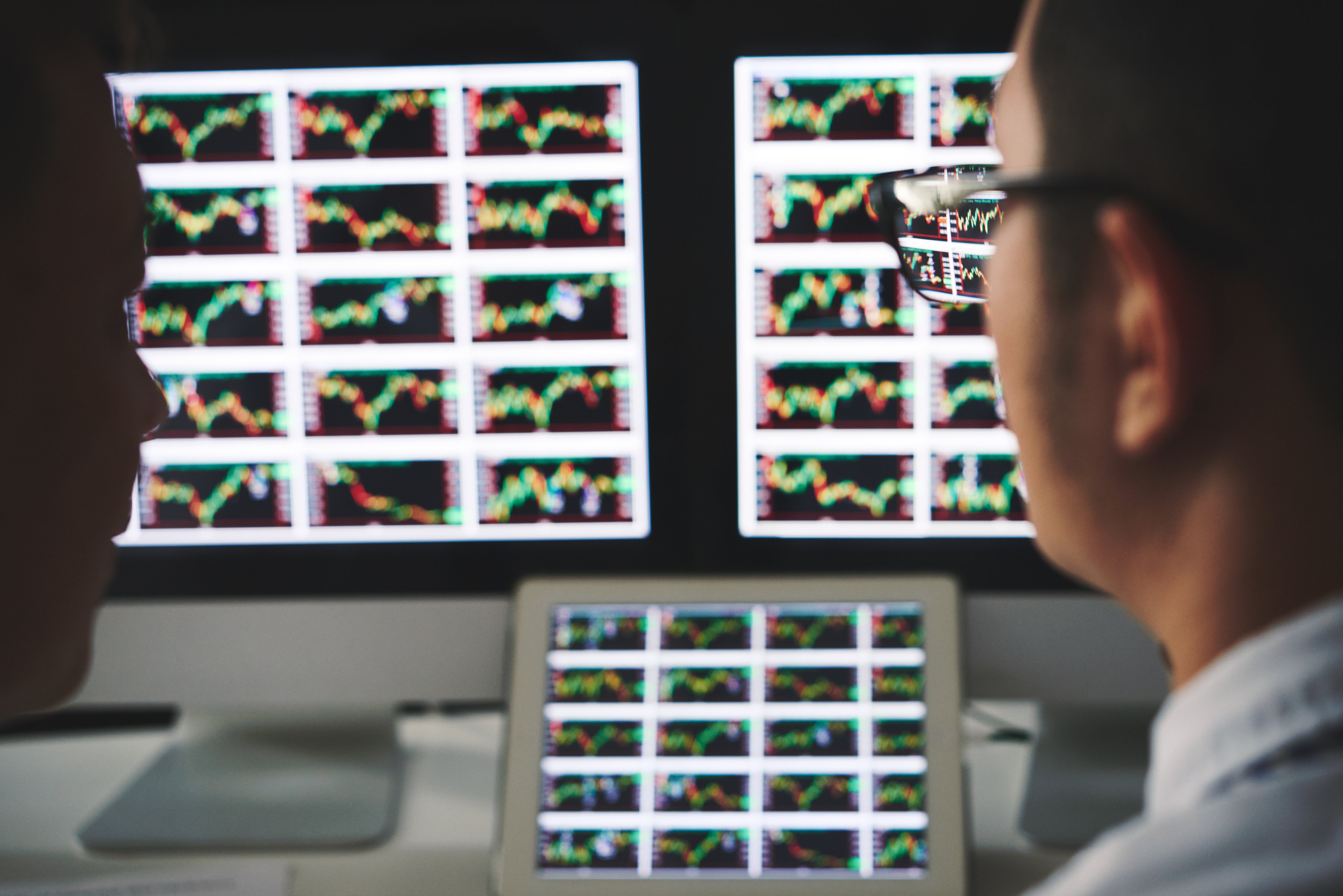 A person looking at screens with charts on them.