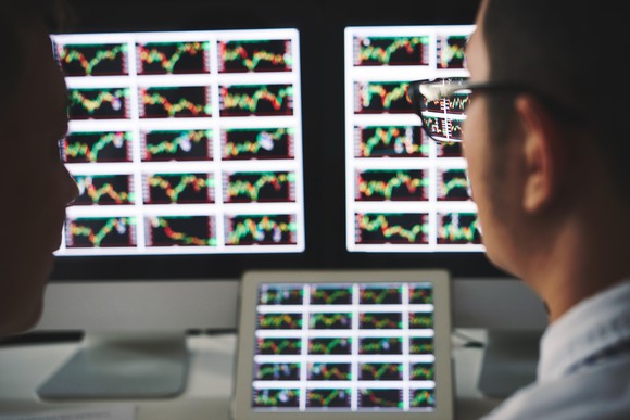 A person looking at screens with charts on them.