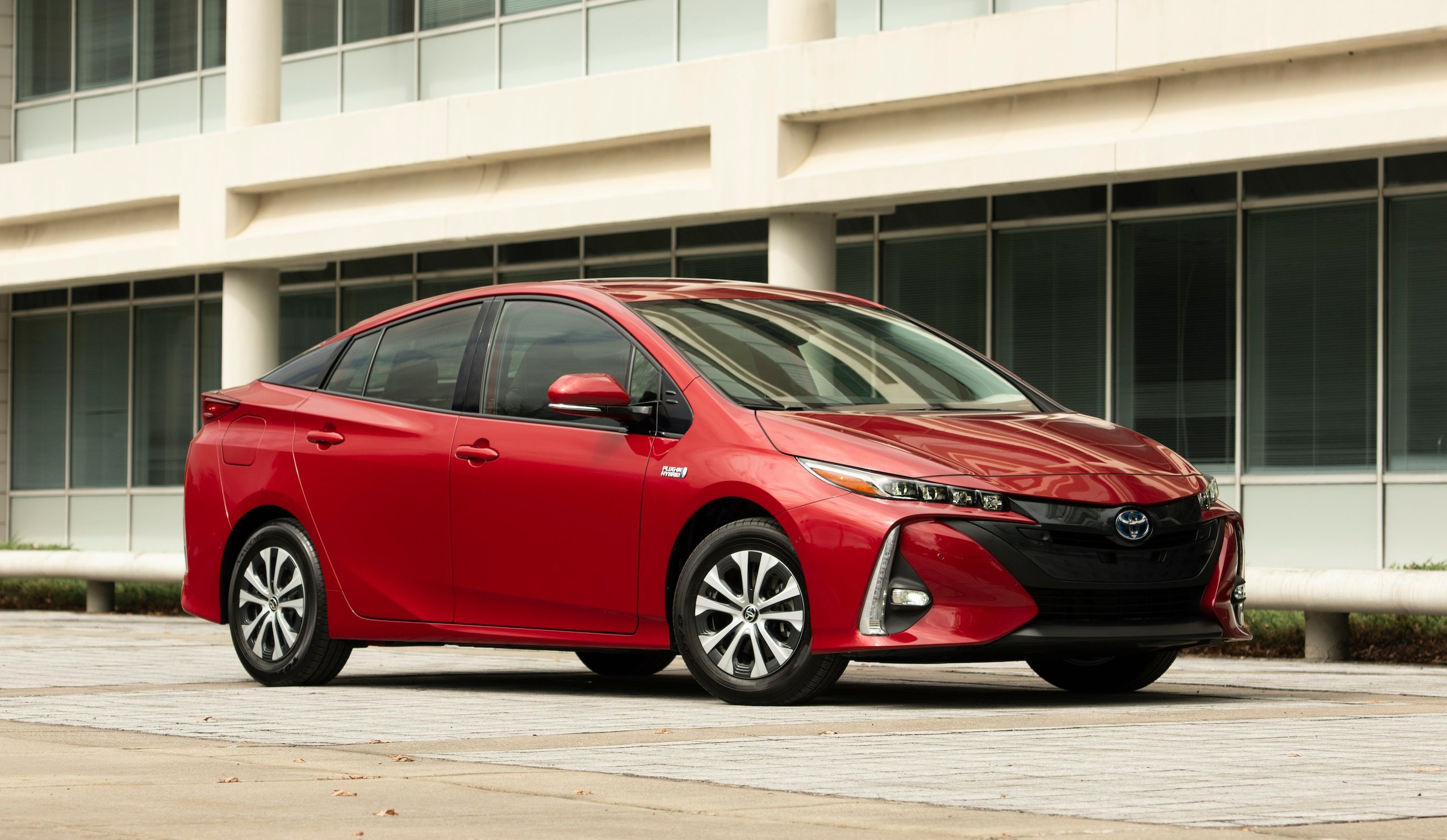 A red 2021 Toyota Prius Prime, a plug-in hybrid sedan. 