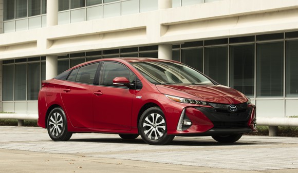 A red 2021 Toyota Prius Prime, a plug-in hybrid sedan. 