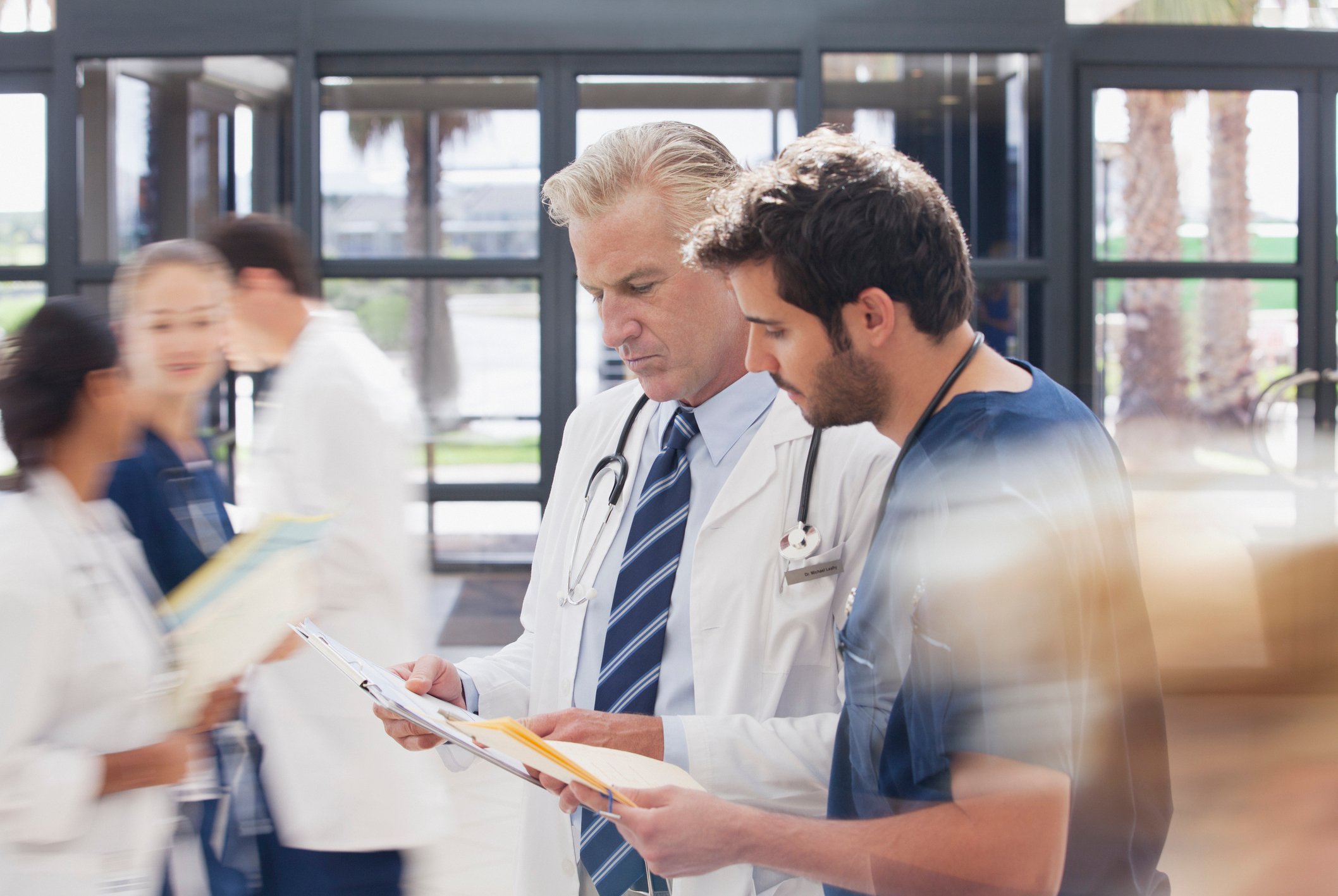 Healthcare professionals conferring in a hospital lobby.