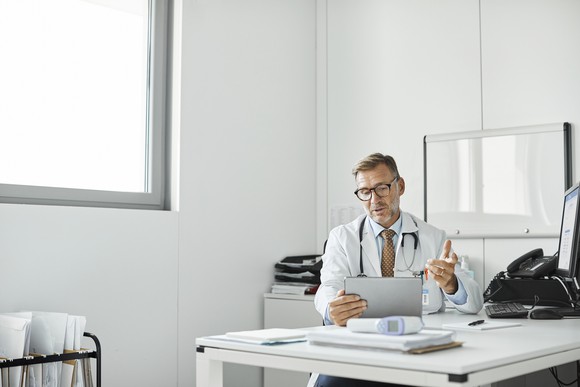 A doctor giving a video consultation on a tablet.