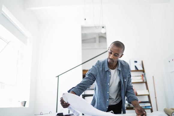 Man looking over some architectural designs.