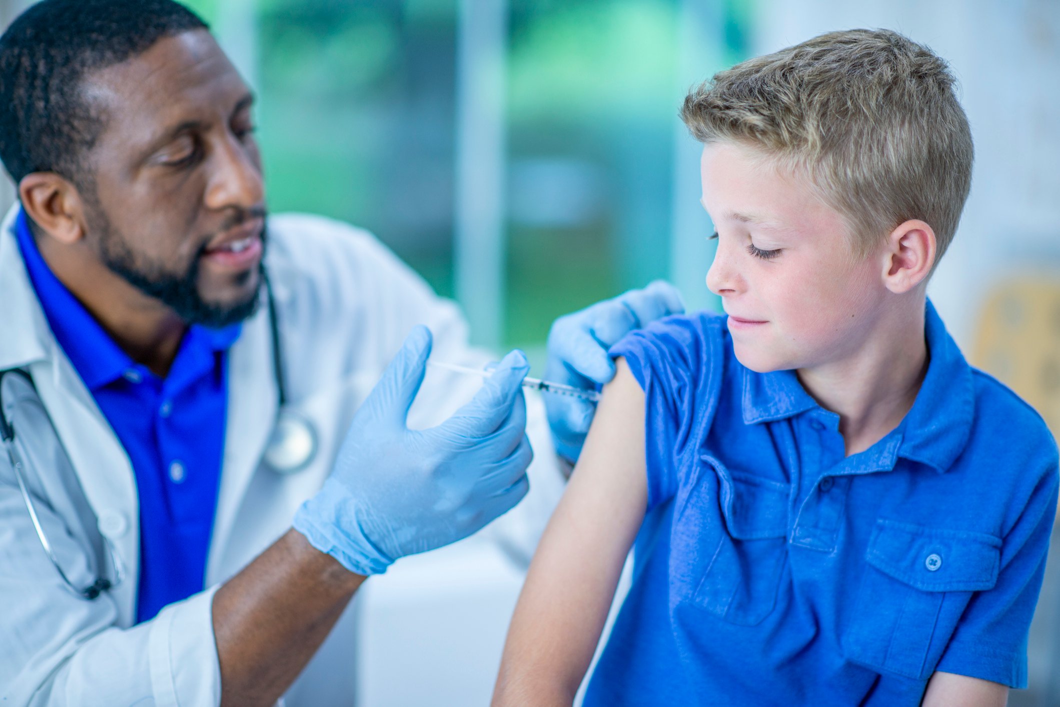 A medical professional is administering a vaccine to a child. 