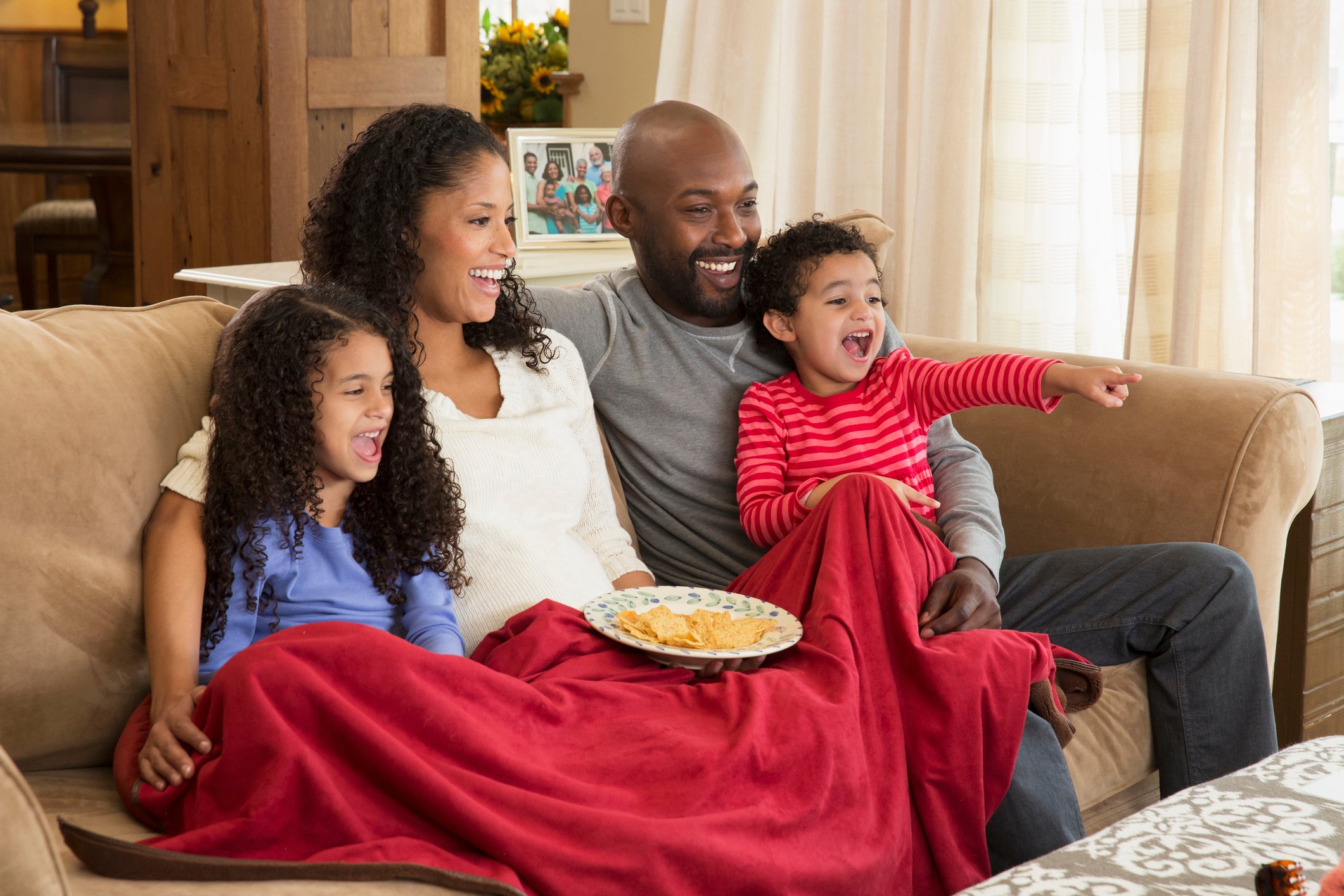 family sitting on couch and watching TV