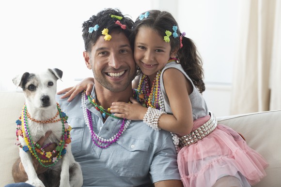 A parent and child and dog all playing dress up.