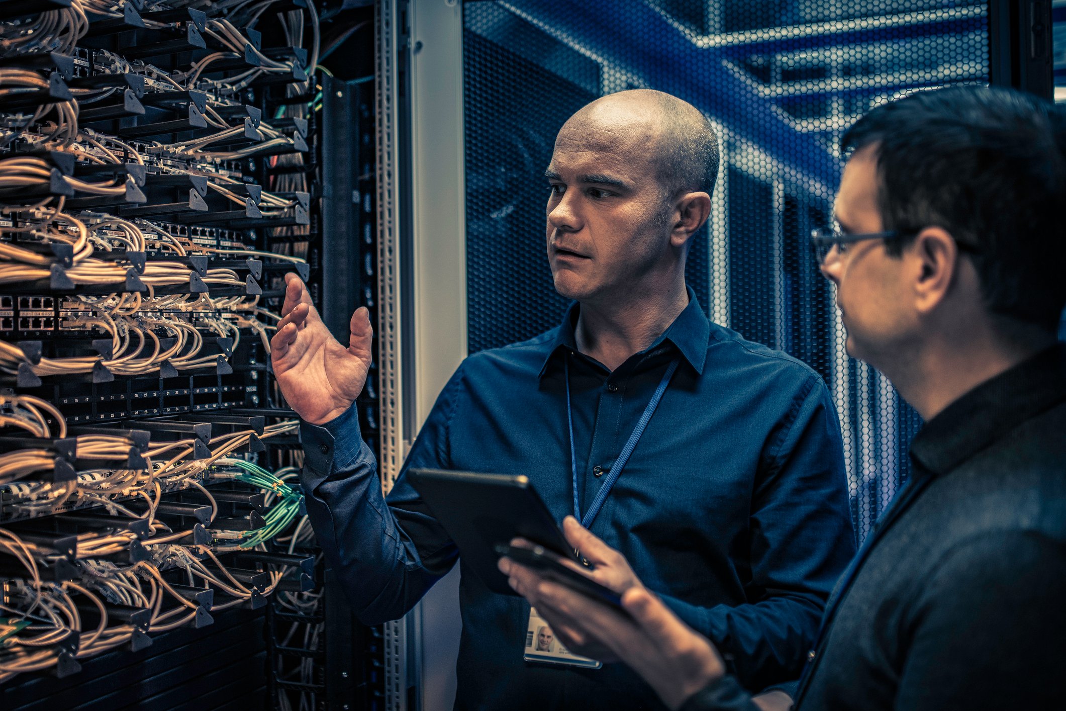 Two individuals are checking on the cloud servers in a data center.