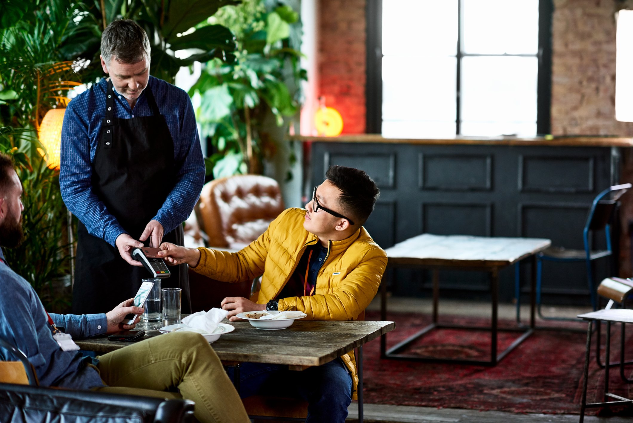 Paying the bill at a restaurant with a credit card.
