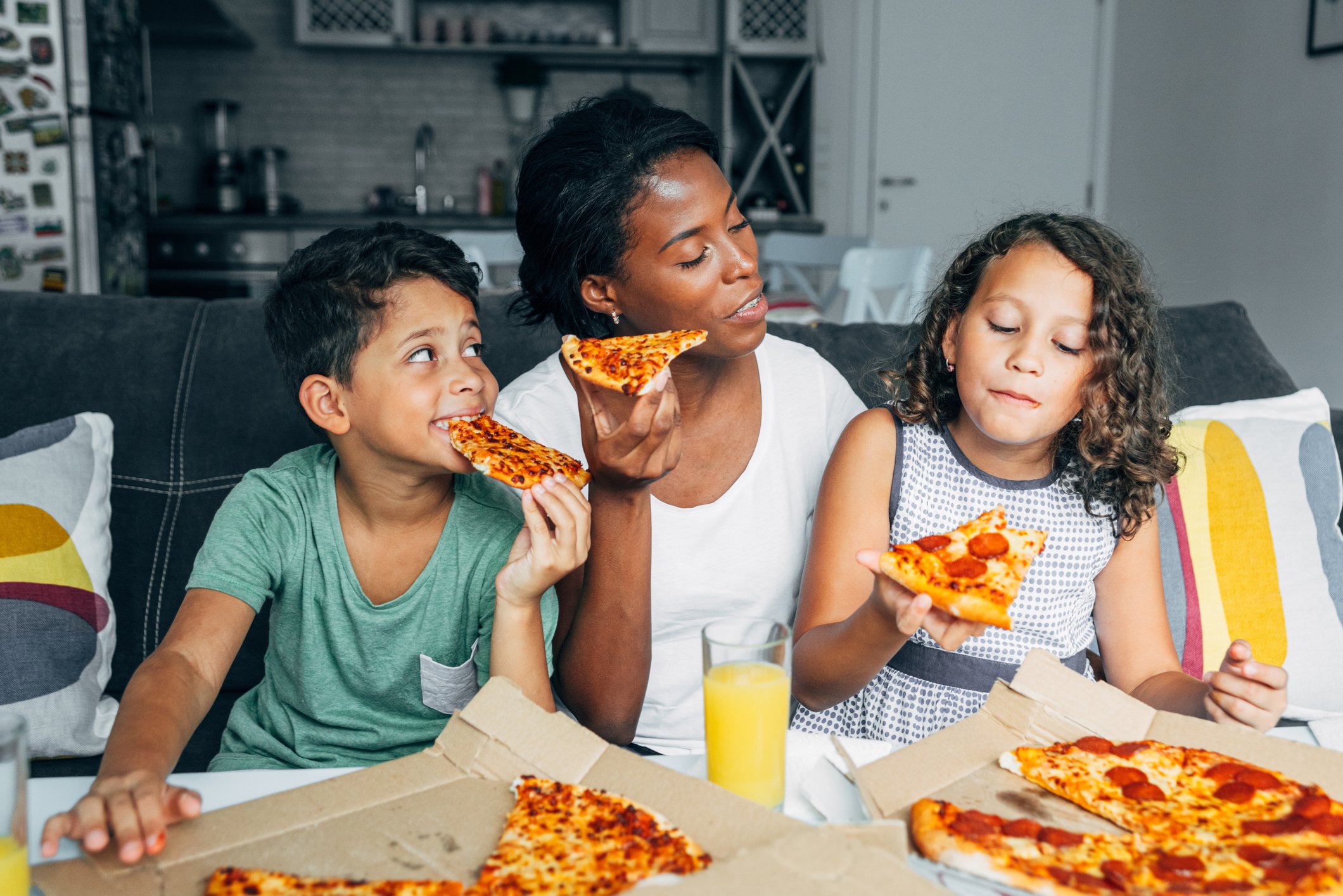 A family eating pizza at home.