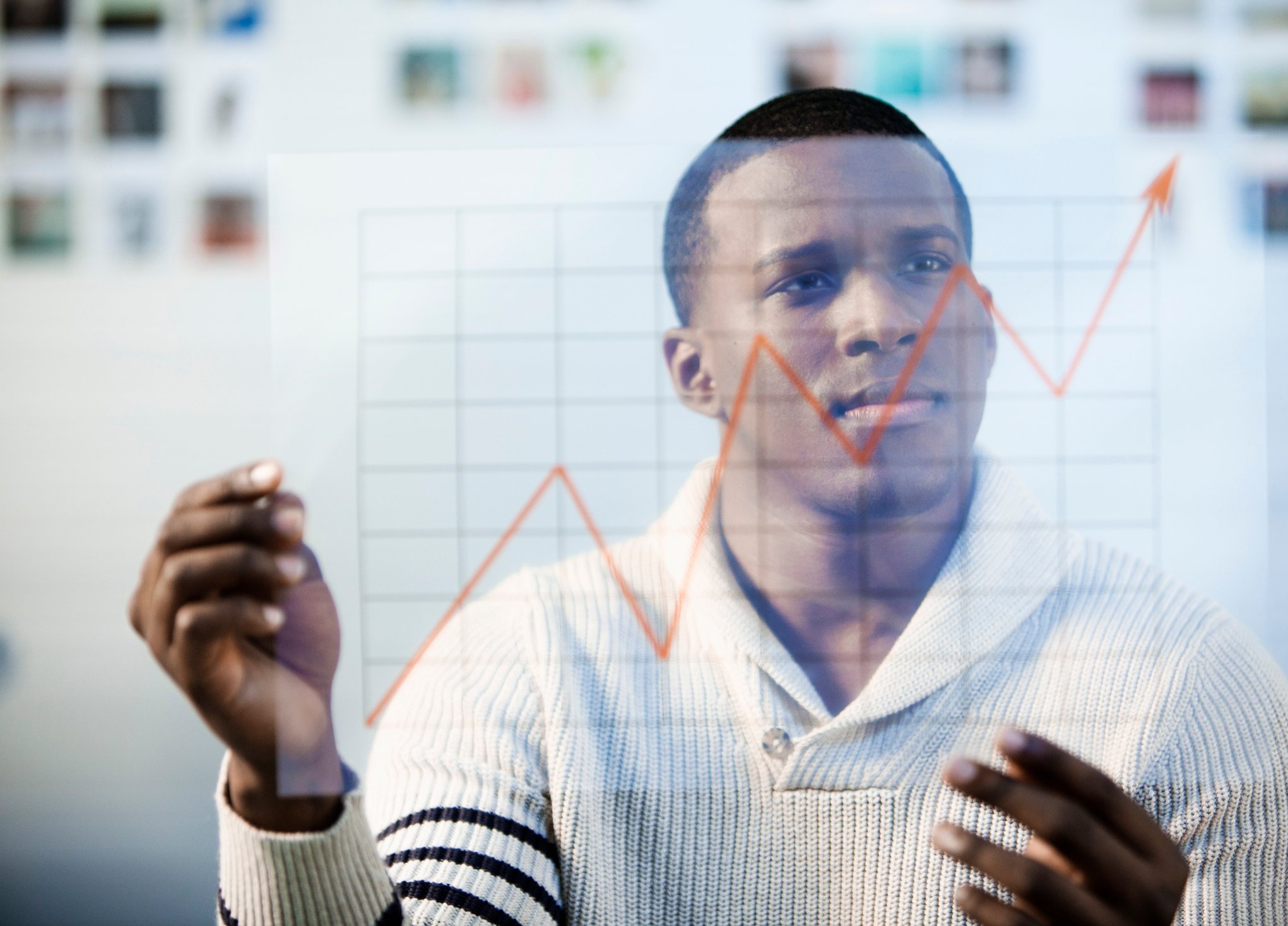 A person looking at a line chart trending upward.