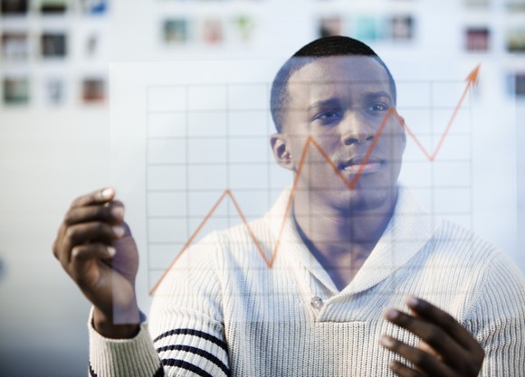 A person looking at a line chart trending upward.