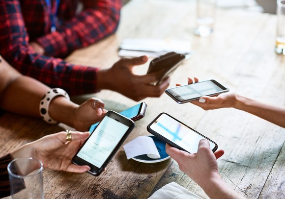 five people splitting a bill with their smart phones