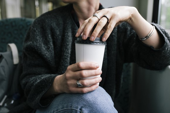 Person holding a cup of coffee.