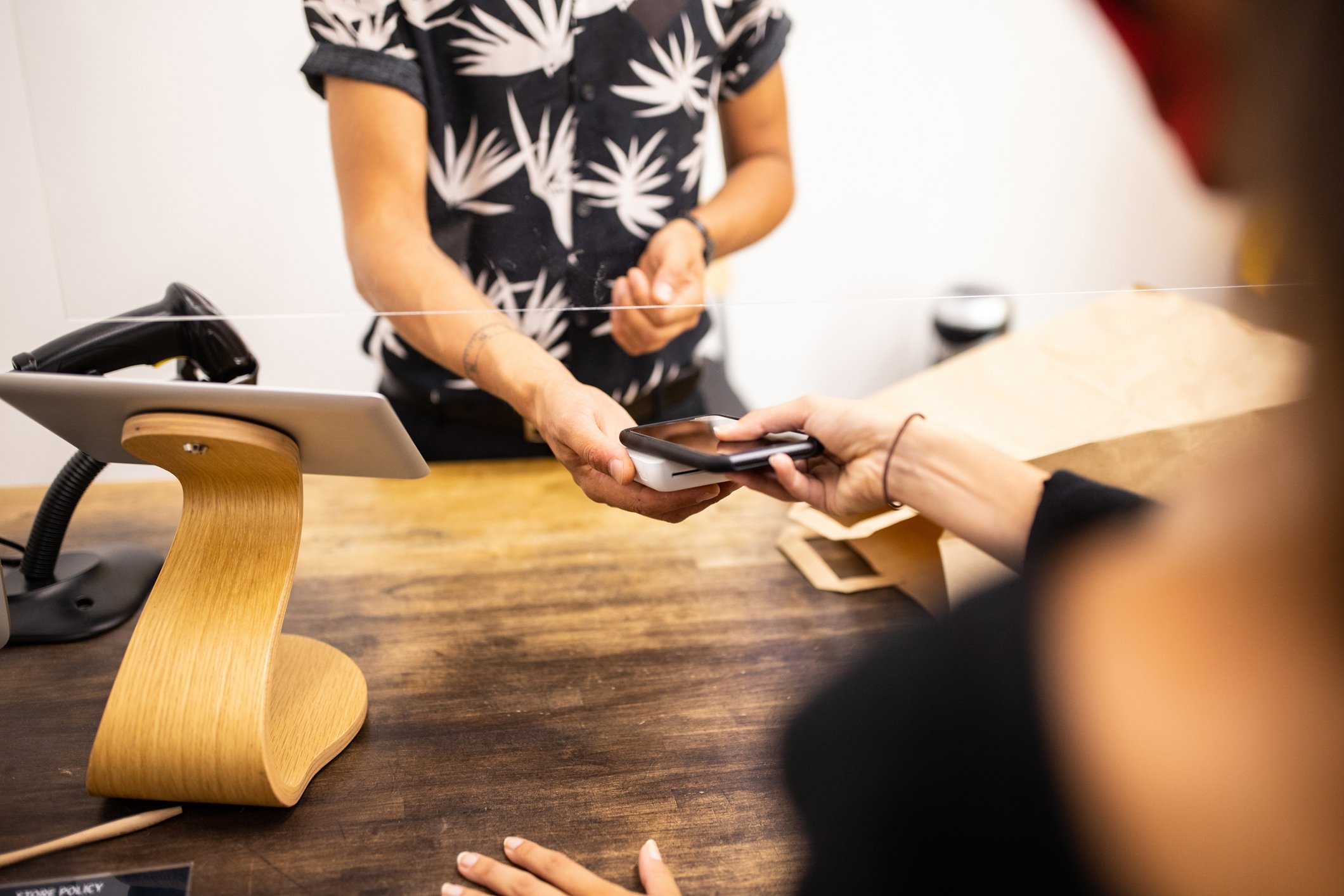 Person checking out with contactless payment on phone.