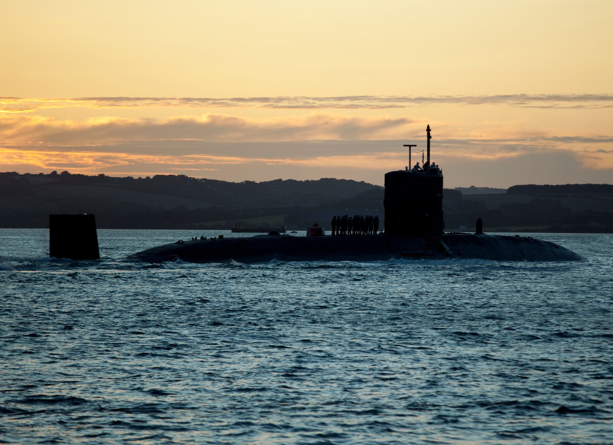 A submarine in the water at dusk.