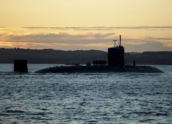 A submarine in the water at dusk.