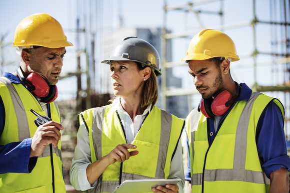 Crew discussing plans at a construction site.