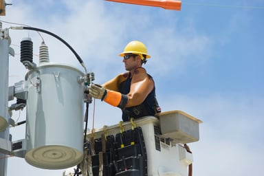A utility worker repairs a power line