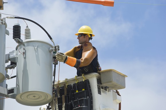 A utility worker repairs a power line.