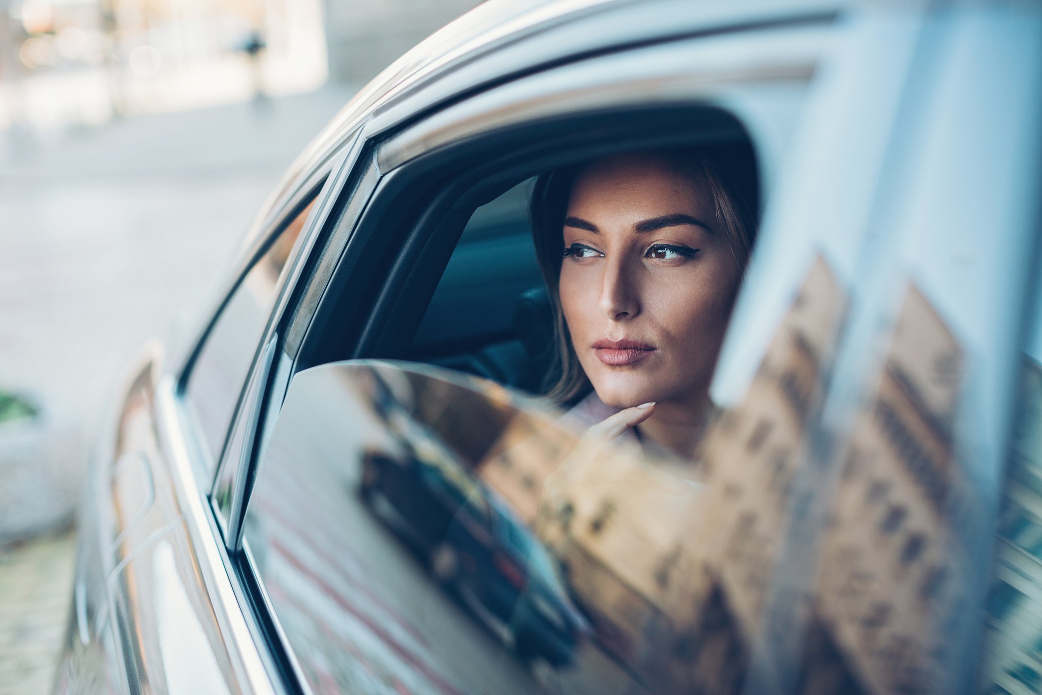 Rich business person staring out car window.