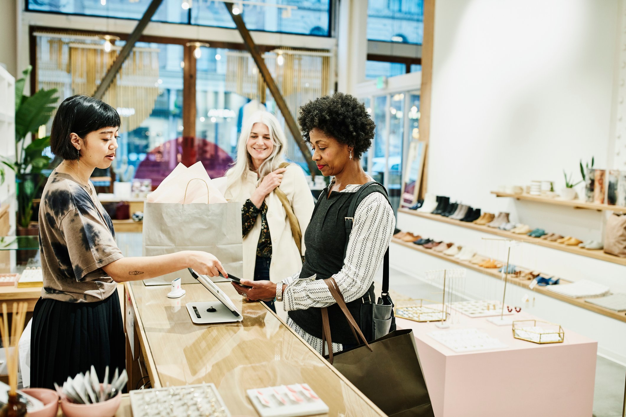 Person paying with smartphone at a clothing boutique.