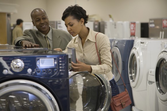 Two people shopping for a washing machine.