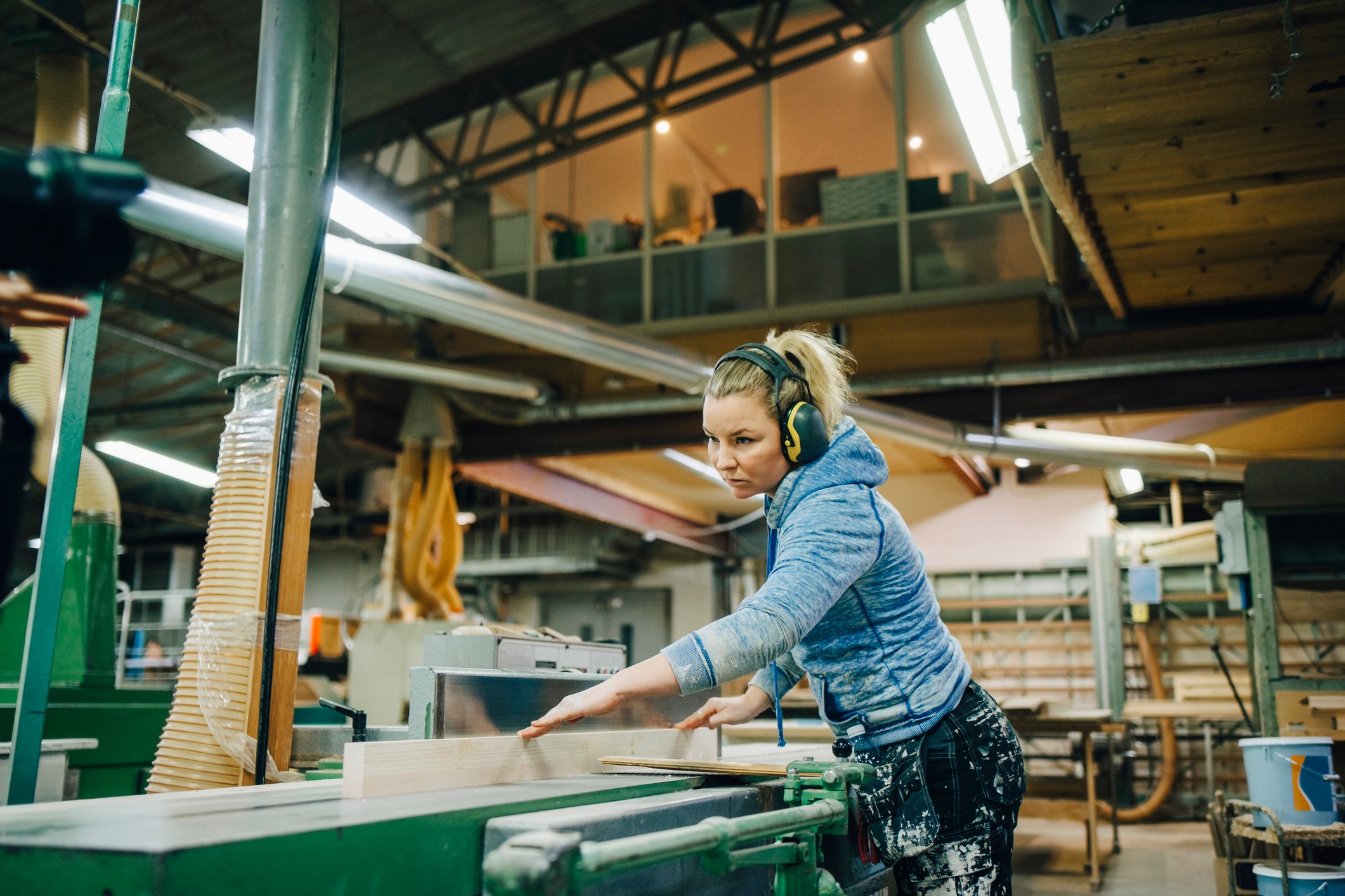 A person cutting wood with a machine.