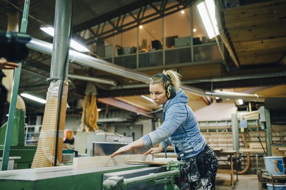 A person cutting wood with a machine.