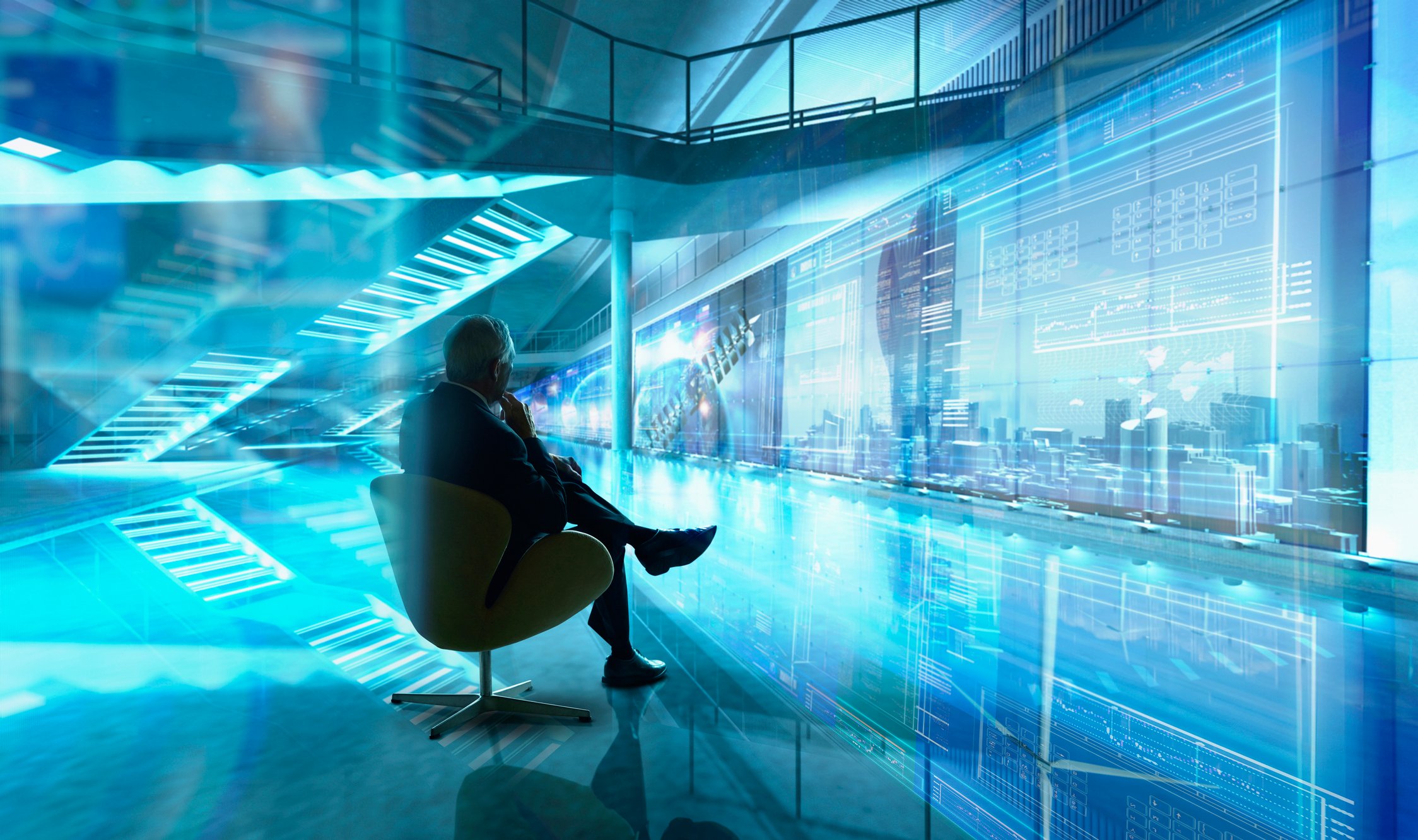 A person sitting in a room looking at digital holograms of the future.