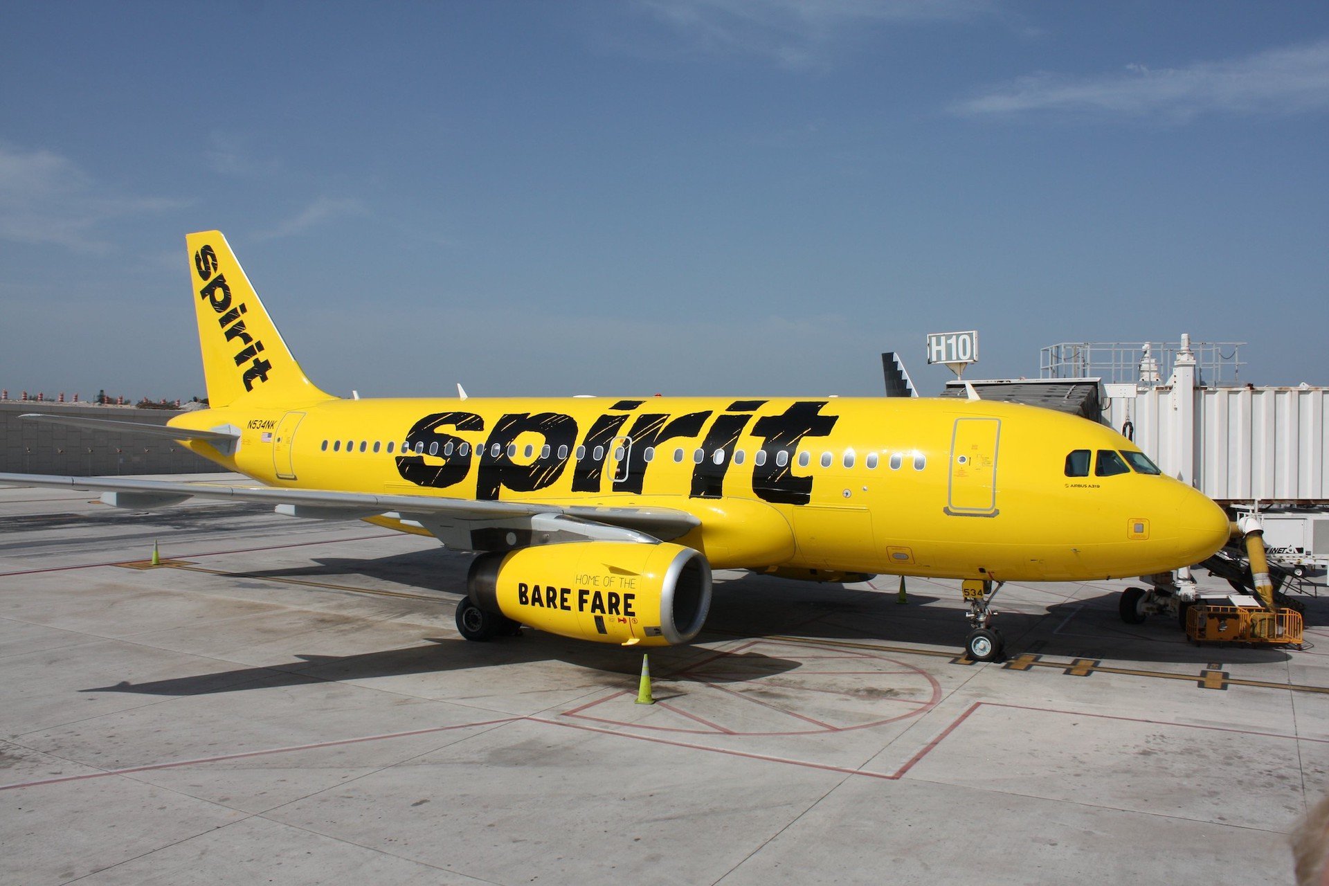 A Spirit Airlines A319 jet parked at an airport gate.