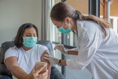 GettyImages-woman takes selfie_doctor vaccinates