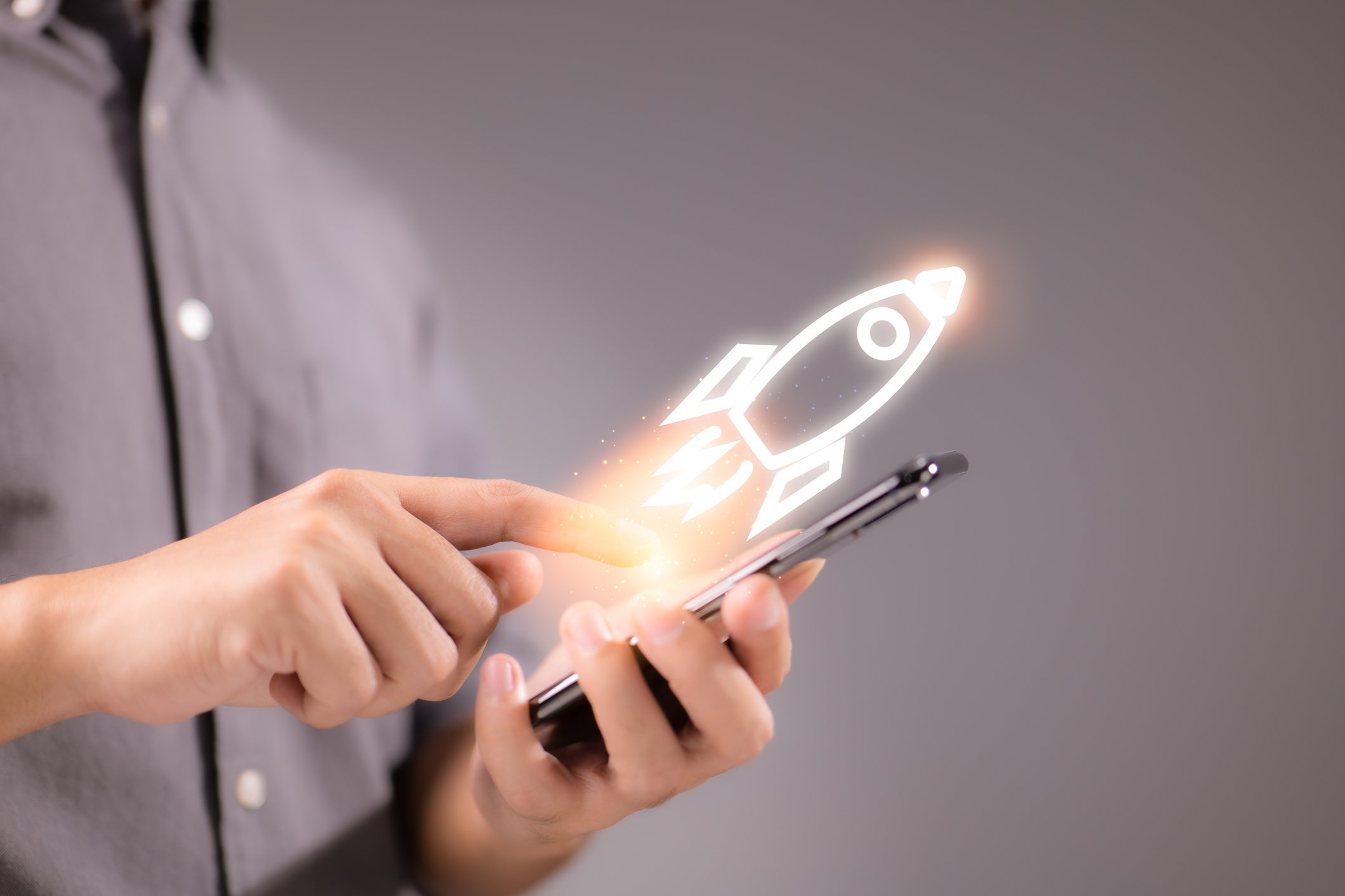 A digital rocket launches off of a smartphone.